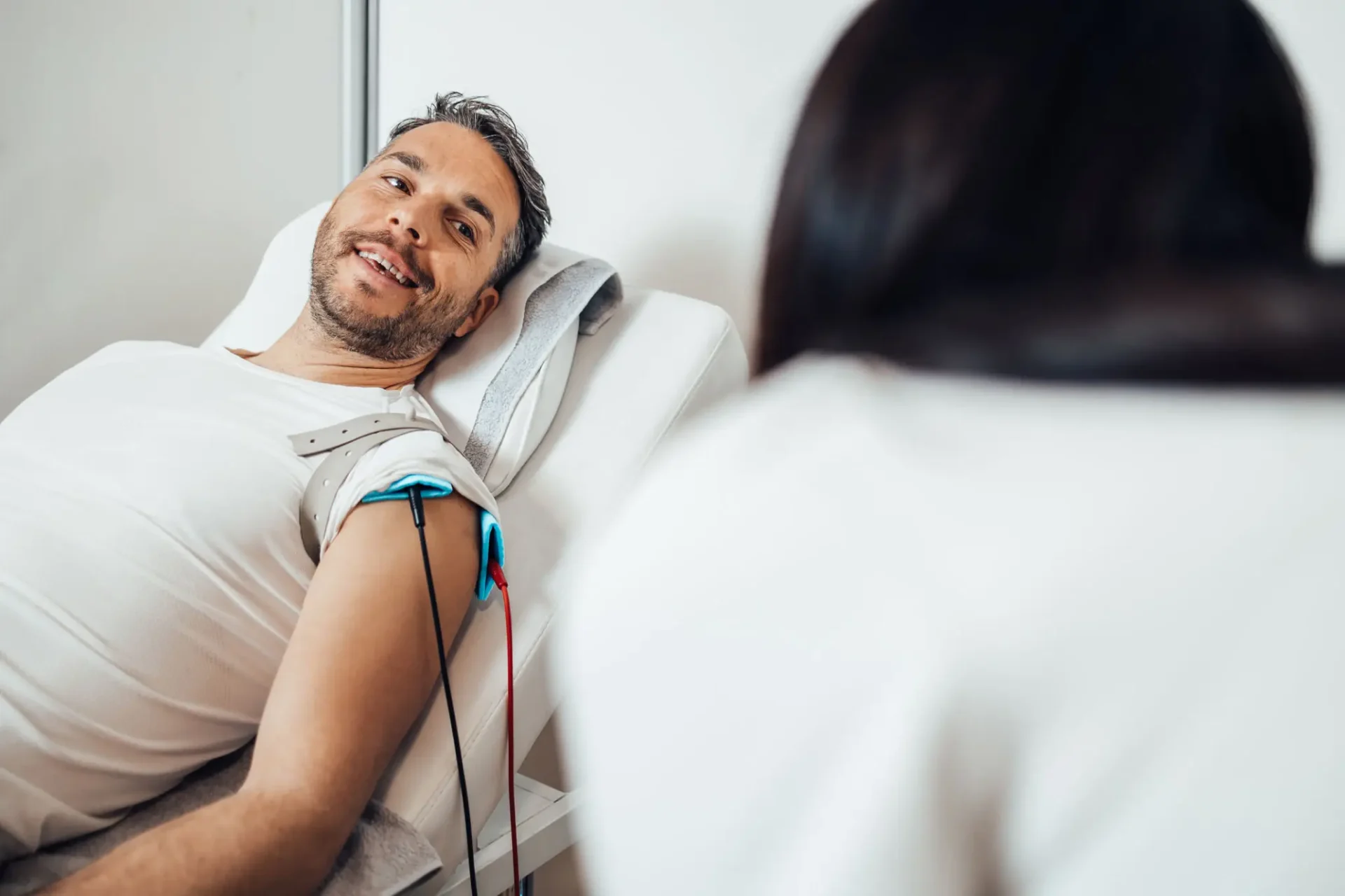 Patient with electrodes smiling at healthcare worker